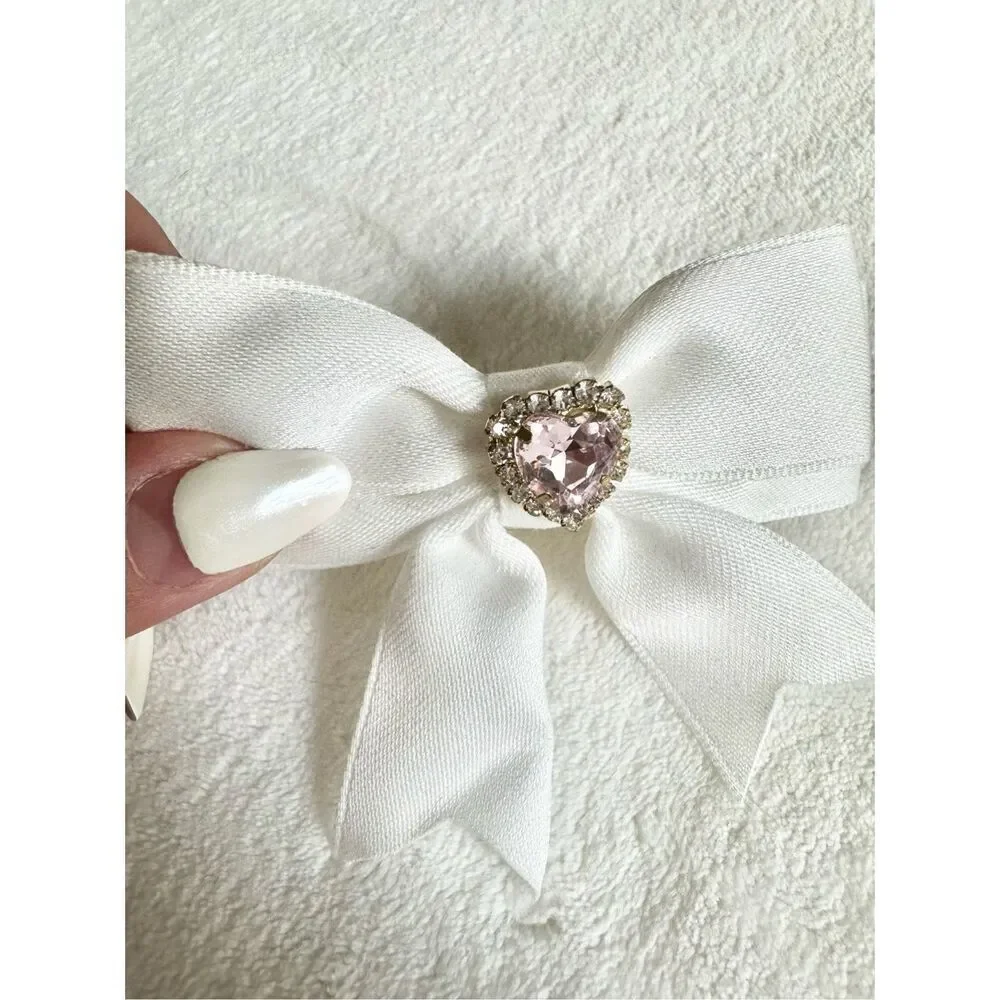 White bow hair clip with pink rhinestone heart ￼